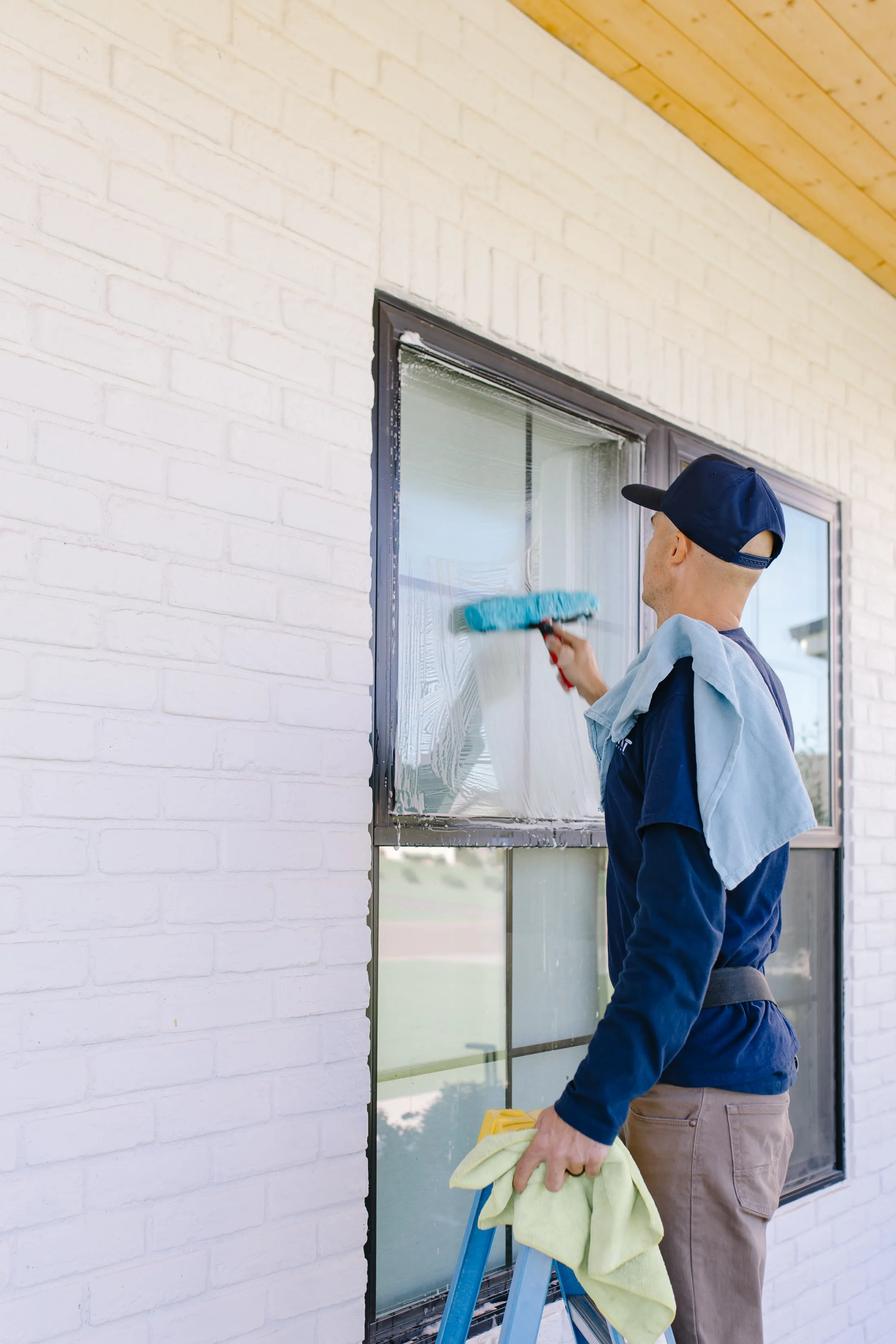 MiNT technician scrubbing a window with a wand