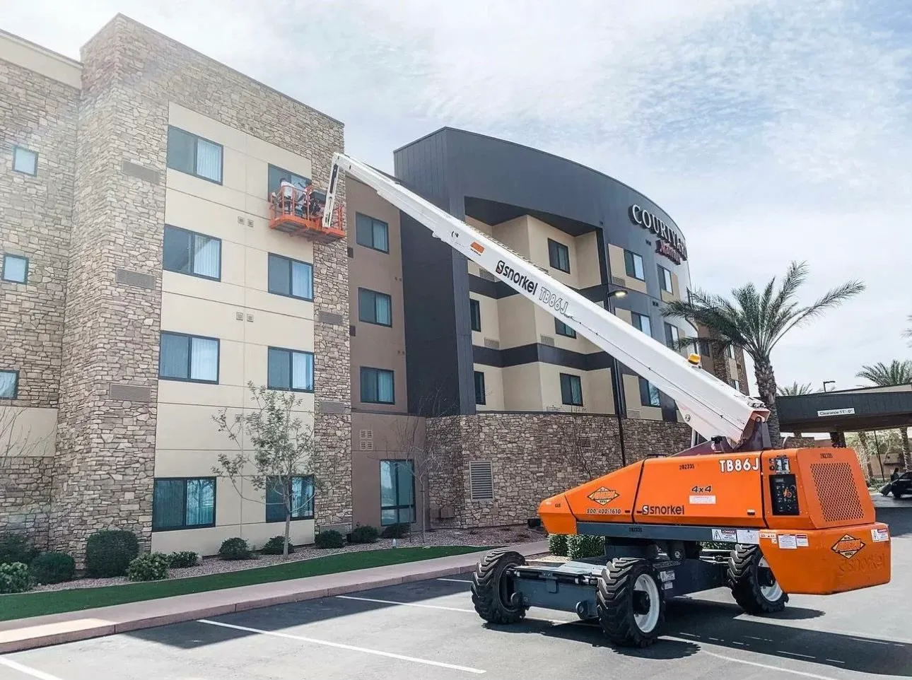 Boom lift raised against a multi-storey commercial building