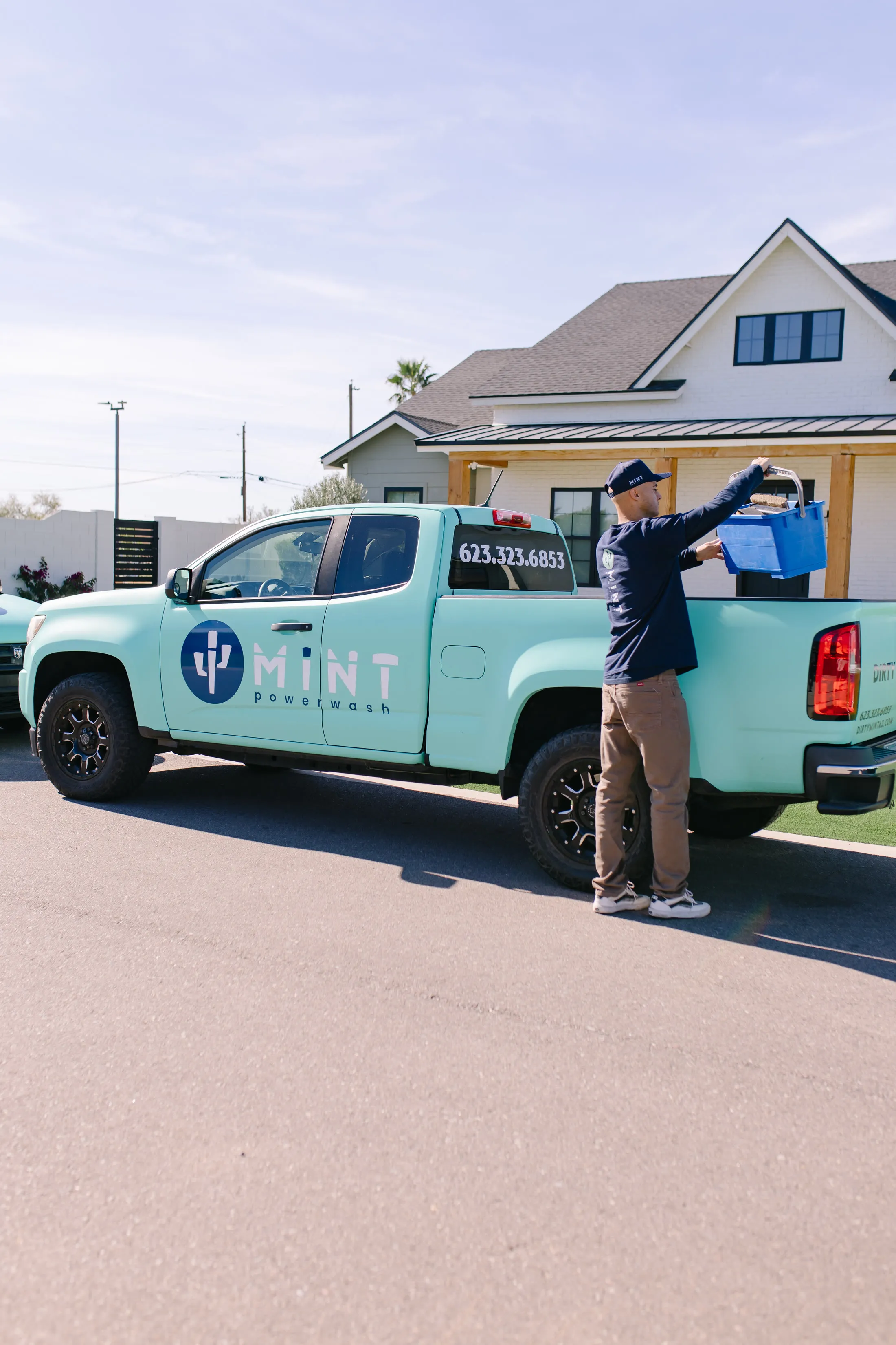 MiNT technician carrying a bucket beside a mint truck
